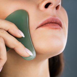 woman using gua sha stone